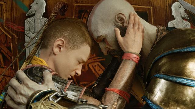 Kratos and Atreus are touching foreheads, Kratos's hands are on Atreus's shoulder, and Atreus's hands on the sides of his father's face. Their facial expressions are solemn.