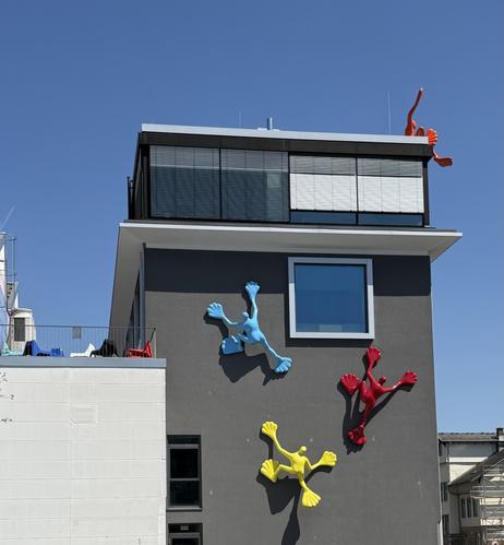 A modern building with some sculptures on the wall climbing up