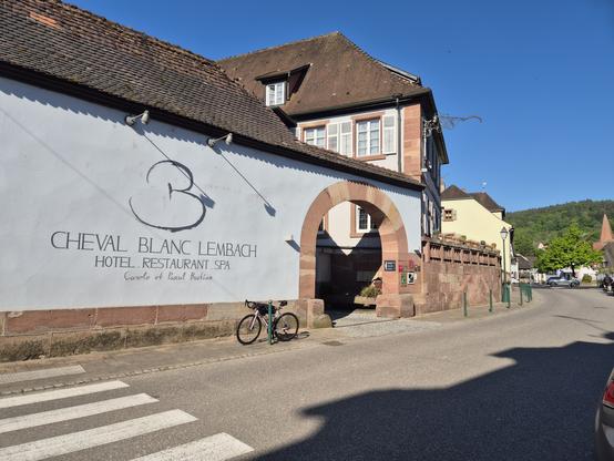 Mon vélo posé devant le porche d'entré du restaurant "Le cheval blanc" à Lembach (Bas-Rhin)