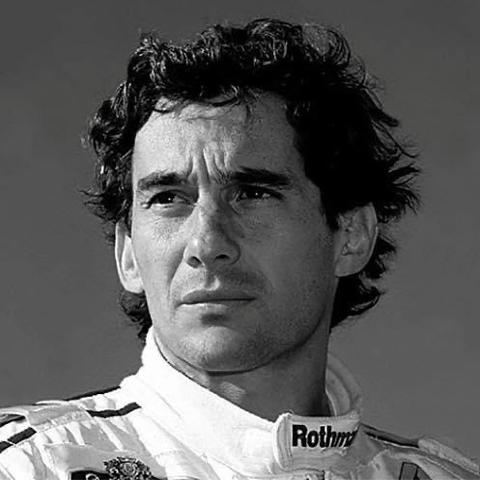 Black and white portrait of a racing driver (Ayrton Senna) with curly hair, gazing thoughtfully into the distance. The individual is wearing a Williams racing suit with a "Rothmans" logo on the collar.