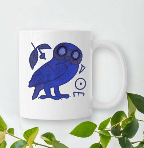 Mug céramique blanc entouré de végétation. Il est illustré par une de mes réalisations, une chouette d'Athena bleue.