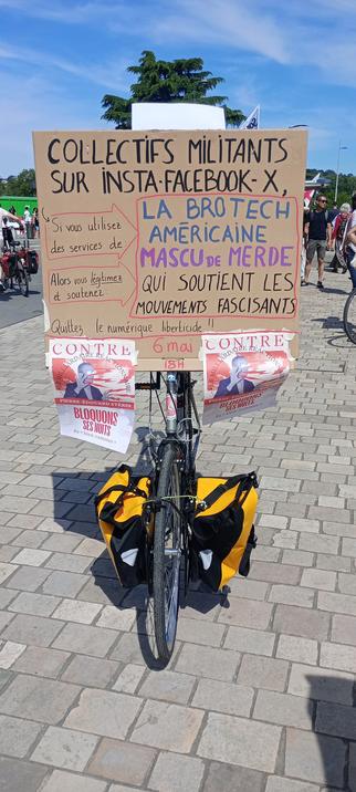 Un tall-bike (vélo sur un vélo) avec une pancarte "Collectifs militants sur Insta-Facebook-X, si vous utilisez les services de la brotech américaine mascu de merde qui soutient les mouvements fascisants, alors vous légitimes et soutenez la brotech américaine mascu de merde qui soutient les mouvements fascisants.Quittez le numérique libre",ainsi que des affiches "Contre  le milliardaire réactionnaire Pierre-Édouard Stérin. Bloquons ses nuits du 'bien commun'"