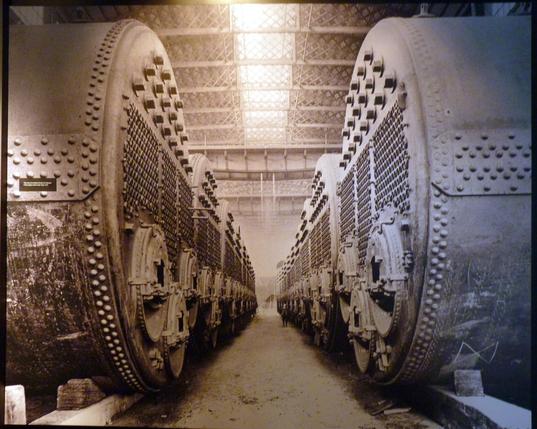 Two rows of ship's boilers destined for Titanic. A man is part way down the rows - indicating the scale