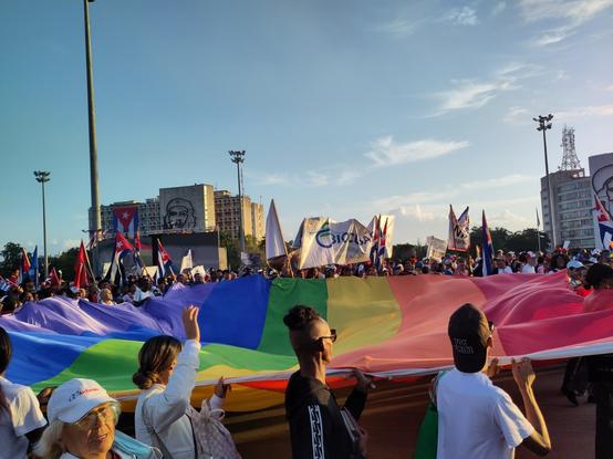 An image of the middle of the May Day Brigade in Havana on La Plaza De La Revolución showing a pride flag