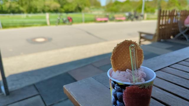 Ein Becher Eiscreme mit Waffel, verschwommen im Hintergrund mein Fahrrad.