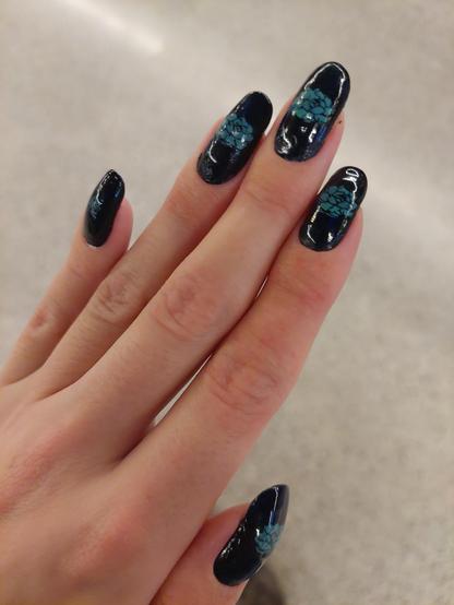 The nails on my left hand. Painted dark blue with a turquoise flower in the middle. My pinky finger has a different smaller flower on it.