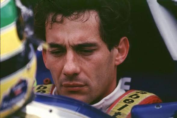 Imagem de Ayrton Senna bastante concentrado sentado no cockpit da Williams. Ele tá sem capacete o capacete e o volante estão diante dele sobre o carro. 

Segue o texto:


Há dias em que é melhor não trabalhar 

Situações em que é salutar não correr.

Ocasiões em que é preferível não participar de um circo desses.

Não te contratará jamais time inglês algum para operar gambiarras inúteis, indignas e assassinas.

Não, jamais um time em inglês. 

Mas às vezes é preferível não confiar nem mesmo nos times dos ingleses. 

Há vezes, sabe, em que aquela coisa que você mais ama se torna uma grande estupidez. 

Porque os administradores dela 

Decidiram que você é a ovelha da vez. 

Alguns Grandes Prêmios são absolutamente desnecessários.

Nenhum troféu é o bastante, Bandeira quadriculada,

Durante a tarde esperava

O seu retorno pra casa pra mais uma celebração.

Mas a alegria se foi 

Naquele dia absurdo, 

Diante dos olhos de todos,,

De encontro ao mais estúpido dos muros

Que ninguém conseguiu remover. 

O amarelo brilhava, 

Entre linhas verdes e azuis 

Numa velocidade extraordinária,

Bravura digna de heróis.

Ninguém ousava alcançar 

Sua determinação

Naquela tarde voraz em que o sonho acabou.