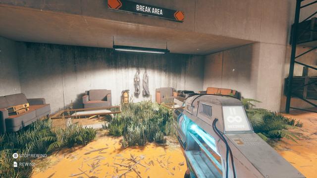An alcove with armchairs, sofas, and coffee tables, but everything is broken and overgrown. 
A sign above reads: BREAK AREA