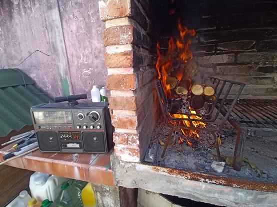 Radio junto a la parrilla con el fuego encendido