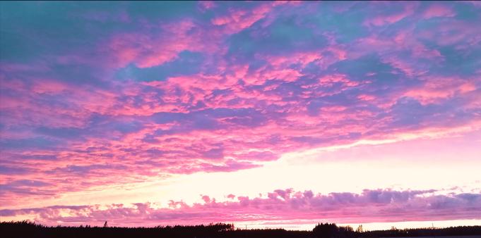 photo of a sunset with bright pink clouds against a yellow and orange glowing sky