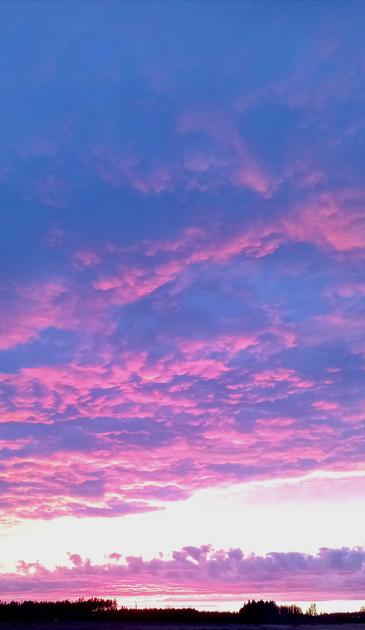 photo of a sunset with bright pink clouds against a yellow and orange glowing sky