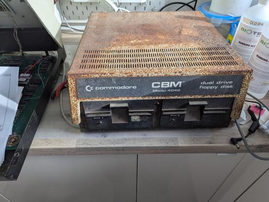 Commodore 4040 disk drive with two 5 and a quarter inch floppy disk drives.  The rusty case will need some work as it has been in a barn for a while.