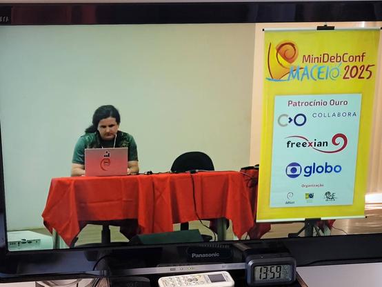 Fotografia de um televisor exibindo a transmissão da conferência.