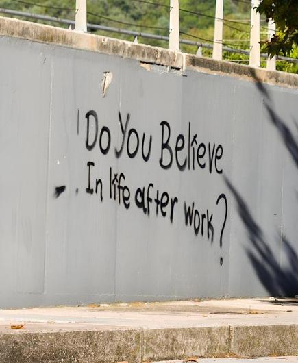 Un muro con la scritta a spray Do you believe in life after work?