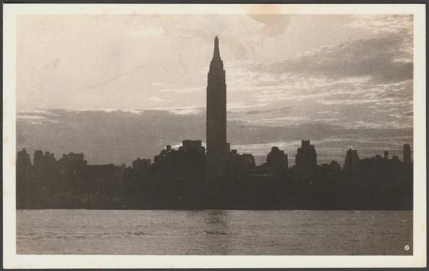 Monochrome real photographic postcard showing a panoramic view of the skyline of New York City, USA, with the Empire State Building prominent to the centre.

Published by and purchased at the Empire State Building, New York City, No 37, c.1950s.

Postally unused.

Good condition, with very slight corner bumps, but some staining to the front.