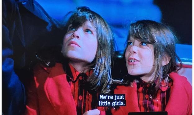 Twin girls of about 8, dressed identically in red coat and Buffalo check top have been grabbed by Mulder. They say: We're just little girls.