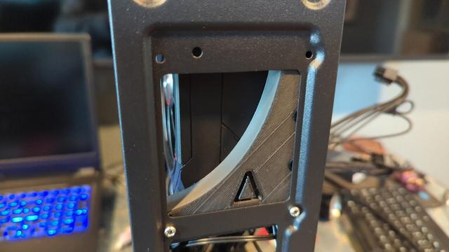 The finished bracket, installed in the case. The screws holding the bracket to the GPU are hidden by the case, but the two screws holding the bracket to the case are visible. Also visible is a triangular "delta" symbol, for a personal touch.
