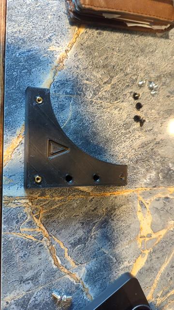 The bracket, prior to installation. The two lower points (bracket to the case) have threaded inserts test fitted. Here you can see the overall shape of the bracket and the different hole types (I plan to redesign the top hole to also work as a passthrough to the GPU's threaded insert).