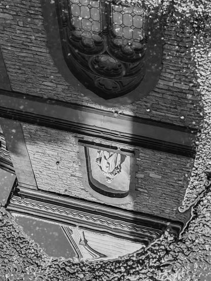 The reflection of a church in a puddle on a street