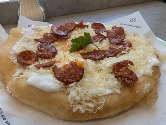 Langos with garlic infused sour cream, cheese and sausage