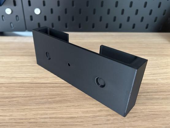 The Thermapen insert is sitting alone on a shelf.  From this angle, two circular indents, 14mm diameter and 3mm deep, are shown.  They clear the screws that hold the shelf front on.