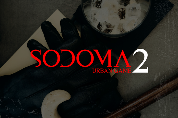 L'immagine presenta un'atmosfera misteriosa e urbana, con un focus su oggetti che suggeriscono un gioco di ruolo o un'esperienza di gioco. Al centro, in caratteri rossi e bianchi, si legge "SODOMA 2" con la sottotitolo "URBAN GAME" in rosso. Sotto il titolo, si intravede una mano guantata di nero, posata su un foglio di carta beige, con un bastone di legno e un oggetto bianco curvo accanto. In alto a destra, un bicchiere con cubetti di ghiaccio aggiunge un tocco di eleganza. Lo sfondo è scuro e grigio, con un effetto di texture che contribuisce all'atmosfera enigmatica.