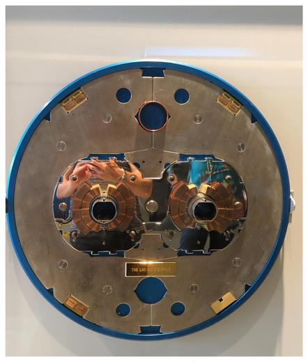 A technical structure from metal on display. A circle with two pipes in the middle, surrounded by magnets.