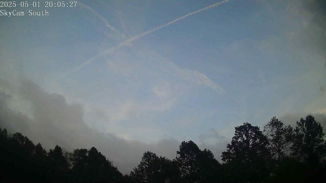 This webcam usually shows a view of the sky with trees in the foreground. It's a cloudy day. It's 64ºF/18ºC.