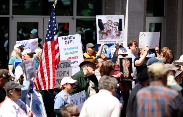 People standing in front of a building holding up signs.