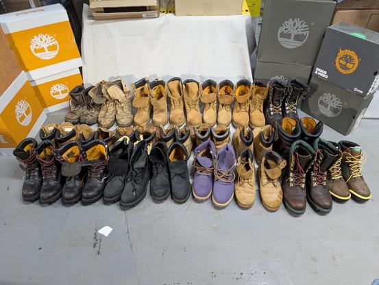 My collection of 22 pairs of Timberland boots are arranged in 3 rows on the floor.
