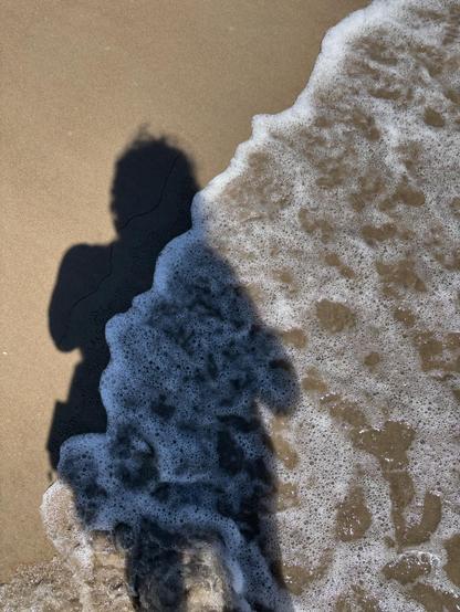 Selfie of me and my backpack in shadow, low ocean surf.