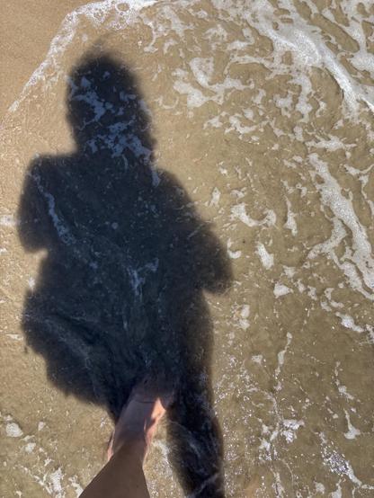 Selfie of me and my backpack in shadow, low ocean surf.