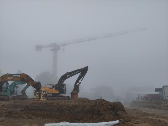 une grue et des machines dans le brouillard