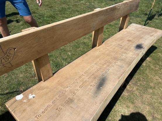 Close up of one of four new wooden benches that were in inaugurated yesterday, made by an artist, each engraved with a poem to the North, East, South and West. This js the West Bench. Bits of the Engraved text captured by AI here (I can’t read it either); 
To earth and chalk. To vic indig across is
To those lost in contic, named and sorens
To a)
