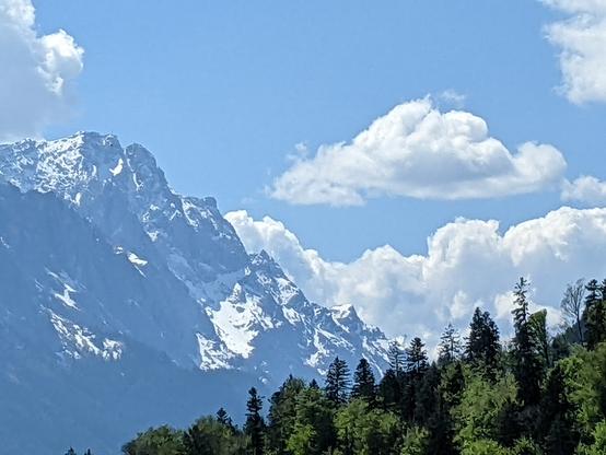 Bavarian Austrian Alps still partially covered in snow with the gondola to the highest peak seen on the side