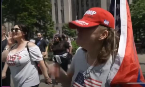 Britisches Ehepaar wird von MAGA-Anhängern in New York von einem Platz vor einem Gericht vertrieben. Die Polizei schirmt die Touristen ab, rät ihnen aber den Platz zu ihrer eigenen Sicherheit zu verlassen. Die MAGAs laufen ihnen nach. Die britische Touristin ist naiv und gibt weiter Interviews - ihr Partner eskortiert sie aus der Situation.