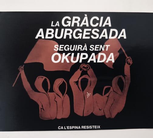 Pegatina con fondo negro. Hay una ilustración de color rojo donde aparecen cinco personas encapuchadas. Dos de ellas ondean una bandera y la del medio alza los brazos generando un corazón con las manos, ésta lleva el símbolo abarcó otra a feminista en la ropa. Por encima de la ilustración aparece un texto en mayúsculas y en blanco con el siguiente texto: la gràcia aburgesada seguirà sent okupada. Debajo, a modo de firma, hay otro texto: Ca l'espina resisteix.