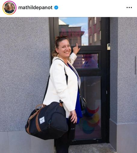 uśmiechnięta francuska polityczka wskazująca palcem na napis na drzwiach przychodni "abotak.org"