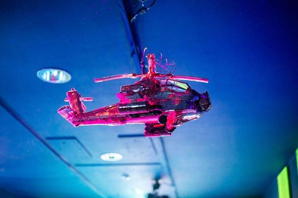 Image: photo of a pink helicopter made out of funky material, viewed from below and to one side, with a blue ceiling behind it; it’s probably not very big • “This immersive exhibition will challenge the language of protest, surveillance, displacement, and defence, creating a space where organising, collaboration, and solidarity take centre stage.    But who are Array Collective?    Array Collective formed in 2016 taking part in the almost weekly rallies and protests in Belfast in solidarity around the issues of abortion rights, LGBTQIA+ rights, the Irish Language Act, Palestine, NHS cuts and climate change. The group devised ways of making a scene and using humour and irony to subvert the language of oppression and containment. Although there has consistently been a need to speak up against atrocities, over the past 18 months there has been a rise in tensions resulting in more than weekly demonstrations. With the increasing threat to public protest and assembly the need for community…”