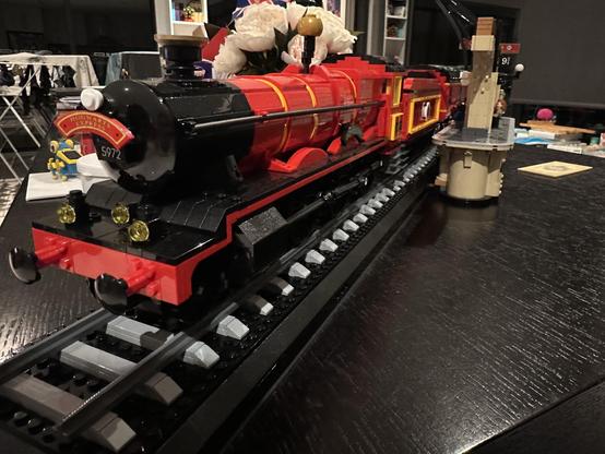 The Lego Hogwarts Express. Taken from the front of the train engine and looking back along the train. The train sits on railway tracks and there a portion of Platform 9 3/4 just visible.