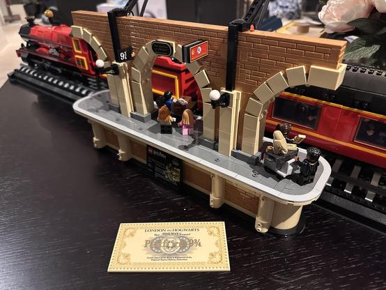 A portion of Platform 9 3/4 sitting in front of the Hogwarts Express (all made from Lego). The platform has Lego minions on it, including the Potters (Harry and Ginny and their kids) waving off Albus Potter and his friend Scorpius Malfoy (a scene from Harry Potter and the Cursed Child).
