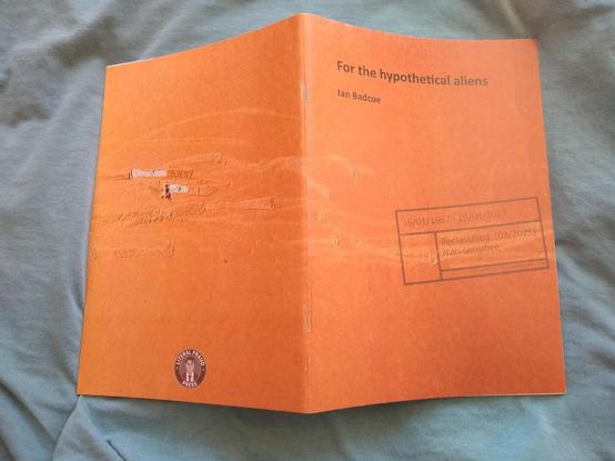 View of the whole, opened cover of a poetry pamphlet called "For the hypothetical aliens" and with a logo proclaiming it is from "Literal Fraud Press".  It carries the image of fake wear and tear, with particularly deep scratches on the back...