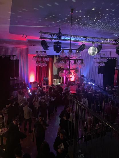 An empty stage with lights in a room full of people