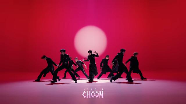 &team performing "Go in Blind" on Studio Choom. One of the members walks towards the camera as he wraps a scarf around his neck like he's attempting to choke himself