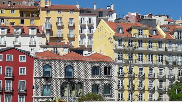 Ensemble de maisons colorées avec du jaune, du rouge, des carreaux blancs et noirs,... à Lisbonne au Portugal.