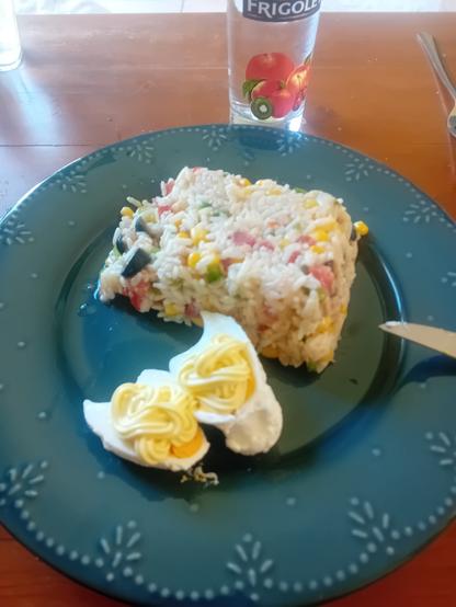 Reste de salade de riz composé et œufs mimosa dans une assiette bleue