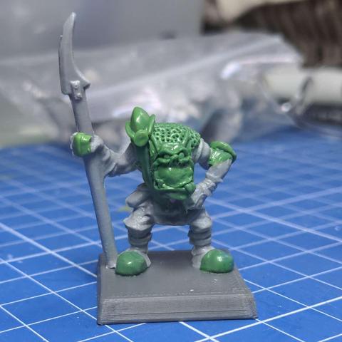 An in progress shot of a plastic model orc with various areas re-sculpted in epoxy putty