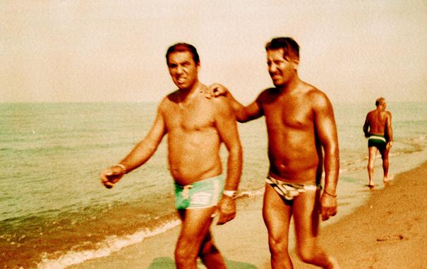 Friendly men taking a stroll along the foreshore on a summer's day, shot on a peculiar analogue film. Taken on 35mm expired & xproed Agfa CT Precisa film using an Olympus TRIP 35 vintage camera and Lomography Color Xpro sunset strip 100.