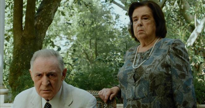 Still from the film ‘Our Father – The Last Days of a Dictator’. Salazar (António Mota) is seated, with his housekeeper Maria de Jesus (Catarina Avelar) standing beside him.