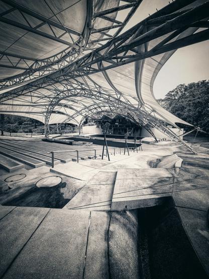 Seemingly bio mechanical inspired scaffolding stretches over a large outdoor auditorium protecting the audience from the harsh Malaysian elements and enhancing acoustics